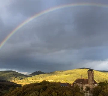 Burg Ludwigstein bei Witzenhausen unter einem Regenbogen – Veranstaltungsort des Azubi-Kick-Off 2025 von EMBRAND