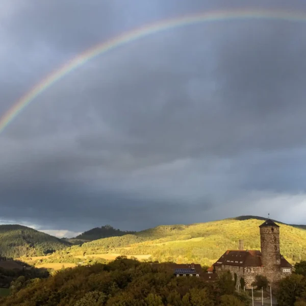 Burg Ludwigstein bei Witzenhausen unter einem Regenbogen – Veranstaltungsort des Azubi-Kick-Off 2025 von EMBRAND
