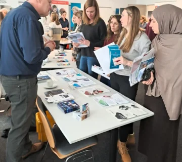 AVGS Veranstaltung im Jobcenter Kassel: EMBRAND Stand mit Informationsmaterial zu AVGS Coaching und IT Coaching im Gespräch mit Teilnehmenden